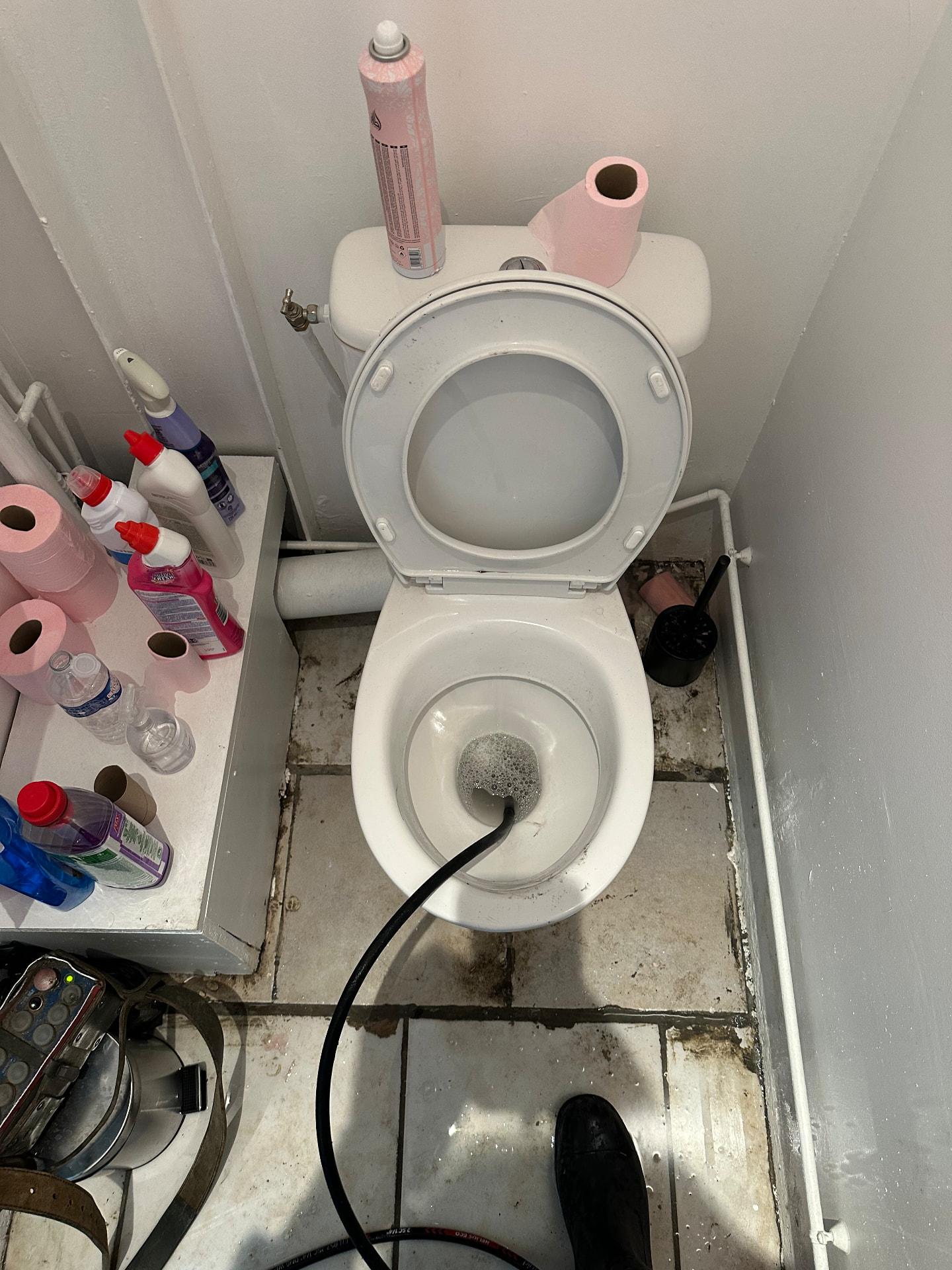 Débouchage de WC en cours dans des toilettes de logement — Versailles